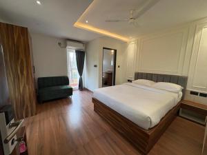 a bedroom with a bed and a chair in it at Lume Stayz in Siolim