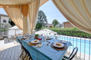 een blauwe tafel met borden vol eten erop. bij Villa Bugatti DesenzanoLoft Official Partner Homes & Villas by Marriott Bonvoy in Desenzano del Garda