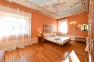 een slaapkamer met een bed en een plafond bij Villa Bugatti DesenzanoLoft Official Partner Homes & Villas by Marriott Bonvoy in Desenzano del Garda +80 foto's