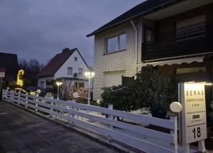 een wit hek voor een huis bij Ferienwohnung in Bielefeld in Bielefeld