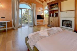 een slaapkamer met een bed en een open haard bij Villa Bugatti DesenzanoLoft Official Partner Homes & Villas by Marriott Bonvoy in Desenzano del Garda