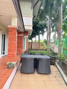 a patio with a table and chairs on a house at NS Private Pool villa in Ban Na Kok