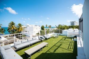 a balcony with white furniture and the ocean at Casa Lotus in San Juan