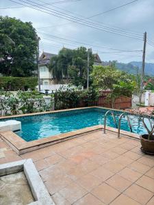 a swimming pool with blue water in a yard at NS Private Pool villa in Ban Na Kok