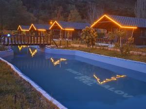 a swimming pool at night with a house in the background at Ruby Bungalow Alanya in Yaylalı
