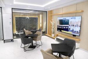 a living room with a tv and tables and chairs at اجنحة نزيل & اجنحة الشمال in Tabuk