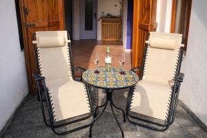 een tafel met twee stoelen en een tafel met wijnglazen bij Mansarda Panoramica nelle Valli di Lanzo Camino & Silenzio in Ceres