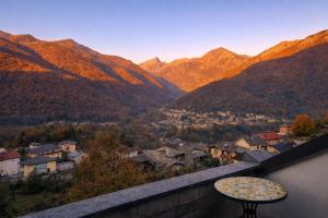 een tafel op een balkon met uitzicht op de bergen bij Mansarda Panoramica nelle Valli di Lanzo Camino & Silenzio in Ceres +1 foto