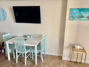 einen weißen Tisch und Stühle mit einem TV an der Wand in der Unterkunft Ocean Walk Resort - Breathtaking Ocean Front View in Daytona Beach