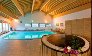 une grande piscine dans une grande pièce dans l'établissement Orelle - Val Thorens, le Hameau des eaux - SPA & piscine, à Orelle