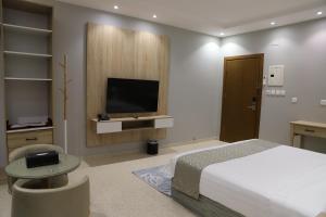 a bedroom with a bed and a flat screen tv at اجنحة نزيل in Tabuk +28 photos
