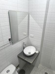 un bagno con lavandino, WC e specchio di Hotel Belle Maison a Chiclayo