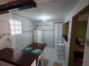 een kleine keuken met een tafel en een koelkast bij Jully's house in Arraial do Cabo