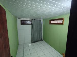 een badkamer met groene muren en een douchegordijn bij Jully's house in Arraial do Cabo