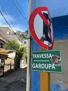 een bord met 'verboden schildpadden' op een paal naast een straat bij Jully's house in Arraial do Cabo