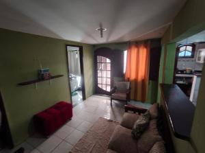 een woonkamer met groene muren en een bank bij Jully's house in Arraial do Cabo