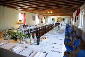a long dining room with white tables and blue chairs at Villa Trigatti in Galleriano