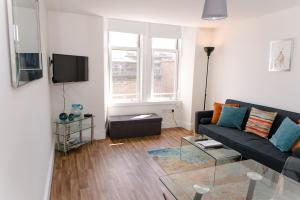 een woonkamer met een bank en een tv bij GreenStar Apartments - Short Walk Away Into Dundee City Centre - Next To Abertay University - Perfect For Your Short or Long Stays - Weekly & Monthly Offers For Your Longer Stays - CLICK FOR OPTIONS - 6 PROPERTIES AVAILABLE FROM 1 TO 3 BEDROOMS in Dundee