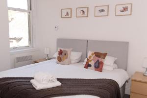 een slaapkamer met een groot wit bed met kussens bij GreenStar Apartments - Short Walk Away Into Dundee City Centre - Next To Abertay University - Perfect For Your Short or Long Stays - Weekly & Monthly Offers For Your Longer Stays - CLICK FOR OPTIONS - 6 PROPERTIES AVAILABLE FROM 1 TO 3 BEDROOMS in Dundee