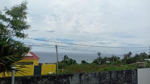 ein gelbes Gebäude mit dem Ozean im Hintergrund in der Unterkunft Studio Vue Mer 24h24 7j7 in Petite Île