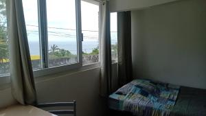 ein Zimmer mit einem Bett und einem Fenster mit Aussicht in der Unterkunft Studio Vue Mer 24h24 7j7 in Petite Île