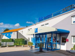 een hotel met een blauw-wit gebouw bij ibis budget Nuits Saint Georges in Nuits-Saint-Georges