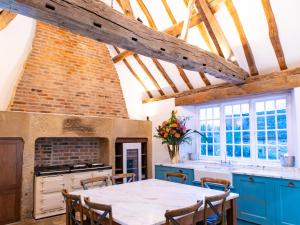 a kitchen with blue cabinets and a table with chairs at Wren Place Hall in Barnsley