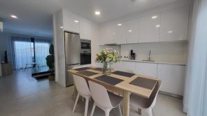 una cucina con tavolo, sedie e vaso di fiori di Boulevard Getaway I a Guanarteme