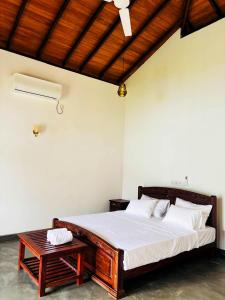 a bedroom with a large bed and a table at Legacy Weligama - 8 min to Weligama Beach in Weligama