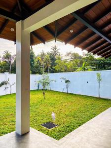 een uitzicht op een grasveld met een muur bij Legacy Weligama in Weligama