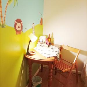 une table avec une lampe et une chaise dans une pièce dans l'établissement Book A Rest Paris, à Longjumeau 19 autres photos