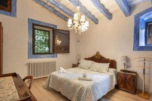 a bedroom with a bed and a chandelier at Masia Brugarolas in Castelltersol