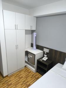 een slaapkamer met witte kasten en een tv op een bureau bij Hotel Belle Maison in Chiclayo +18 foto's