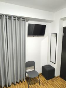 een kamer met een stoel en een flatscreen-tv bij Hotel Belle Maison in Chiclayo