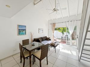 a living room with a table and a couch at Mango Vert Duplex - Orient Bay in Saint Martin