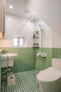 a bathroom with a sink and a toilet and green tiles at Pachira House in Seoul +45 photos