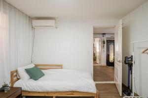 a bedroom with a bed with a green pillow on it at Pachira House in Seoul