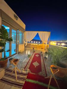 een woonkamer met uitzicht op de oceaan in de nacht bij Shams House imsouane in Imsouane