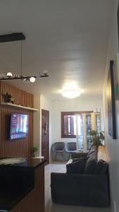 ein Wohnzimmer mit Sofa und Fernseher in der Unterkunft Lar Sousa Rocha in Capão da Canoa
