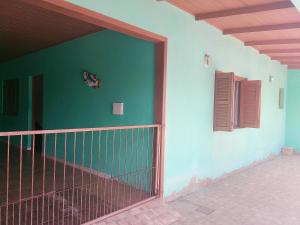 een gebouw met een groene muur en een poort bij Kitnet com garagem e Wi-Fi in Tramandaí