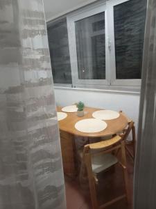 einen Tisch und Stühle in einem Zimmer mit Fenstern in der Unterkunft Linda Apartments- Arena in Novi Beograd + 22 Fotos