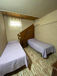 twee bedden in een kleine kamer met ermottermott bij Casa en complejo in San Roque