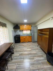 een keuken met houten kasten en een koelkast bij Casa en complejo in San Roque