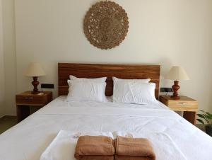 een slaapkamer met een wit bed met twee handdoeken erop bij LUSSO Mirissa in Mirissa