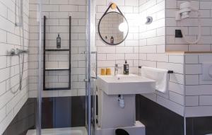 un bagno bianco con lavandino e doccia di ibis Grenoble Gare a Grenoble