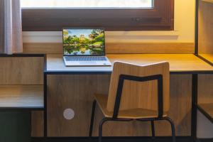 un computer portatile seduto su una scrivania con sedia di ibis Grenoble Gare a Grenoble