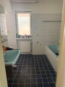 een badkamer met twee baden en een raam bij Haus Heigenbrücken in Heigenbrücken