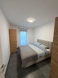 a bedroom with a large bed and a window at Apartments Svetlana, Igalo in Herceg-Novi