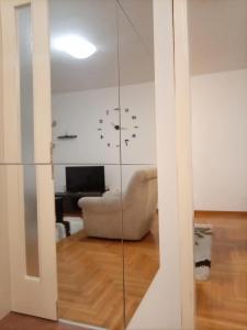 eine Glastrennwand in einem Wohnzimmer mit einem Stuhl in der Unterkunft Linda Apartments- Arena in Novi Beograd