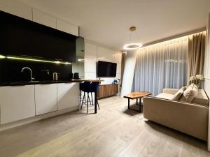 a kitchen and living room with a couch and a table at Blue Reef 6th Floor Sea View in Międzyzdroje